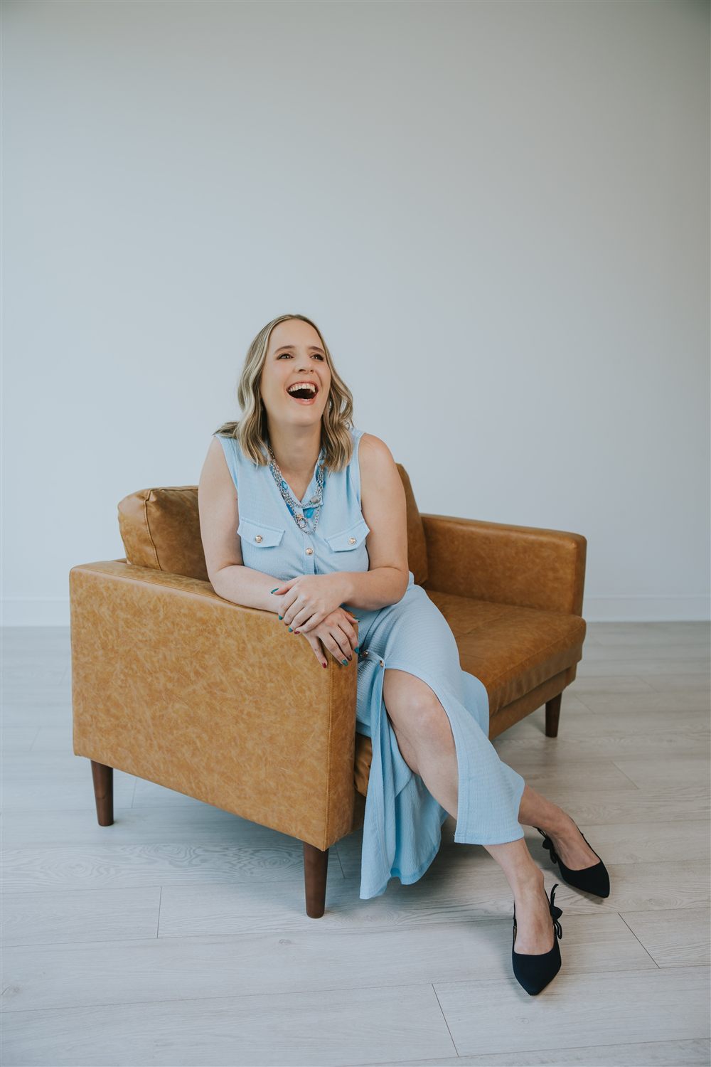 Maren laughing in a leather armchair